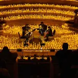 Un concierto de música clásica bajo la luz de miles de velas, evocando la magia de "El Señor de los Anillos".