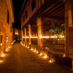 Calle empedrada iluminada por velas. Entradas gratuitas a Pedraza, un pueblo mágico.
