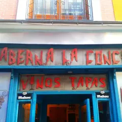 Fachada de la Taberna La Concha, con letrero rojo y azul. Ofrece vinos y tapas. ¡Las opiniones de la taberna La Concha son muy buenas!