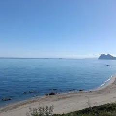 Vista de la playa la Alcaidesa con el Peñón de Gibraltar al fondo. Un día soleado y tranquilo, ideal para disfrutar del mar.