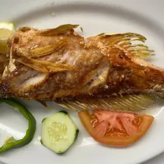 Pescado frito entero, servido con rodajas de limón, pimiento verde, pepino y tomate. ¡Una excelente opción de donde comer en El Hierro!