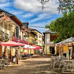 Calle con terrazas de restaurantes en pueblos cerca de León. Hostal La Gallega y Coca-Cola visibles.
