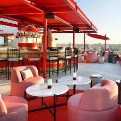 Modernas terrazas azoteas Madrid baratas con mobiliario rosa y barra roja, vistas a la ciudad.