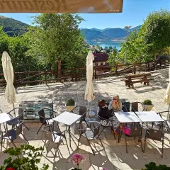 Terraza de restaurante con vistas al embalse. Ideal para saber donde comer en Riaño. Mesas, sillas y sombrillas listas para disfrutar.