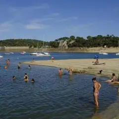 Gente disfrutando de un día soleado en la playa, ¡quién diría que en Madrid hay playa! Barcos y bañistas en un día perfecto.