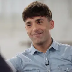 Un hombre sonríe, con su camisa vaquera y un micrófono. Podría ser el mago pop de Madrid.