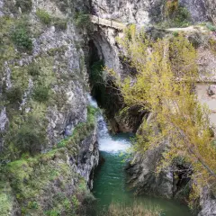 Cascada y ruinas en un cañón. Para saber benilloba como llegar, sigue el sendero entre las rocas y la vegetación otoñal.