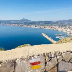 Vista panorámica de la bahía y el puerto deportivo, con el faro del Cabo de San Antonio al fondo.