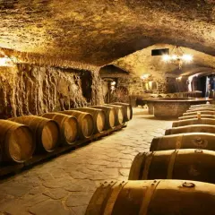 Antiguas barricas de roble esperan en esta bodega subterránea, perfecta para una visita a bodegas.