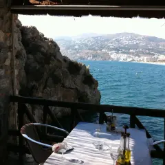 Mesa en restaurante el peñón con vistas al mar. Las reseñas destacan su ubicación privilegiada y la experiencia culinaria.