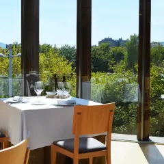 Elegante mesa puesta en un restaurante con vistas a la naturaleza, ideal para descubrir los mejores restaurantes en pueblos cerca de Pamplona.
