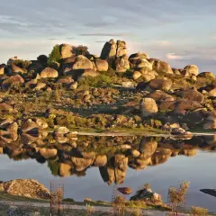 Paisaje rocoso y reflejos en el agua en Malpartida de Cáceres.