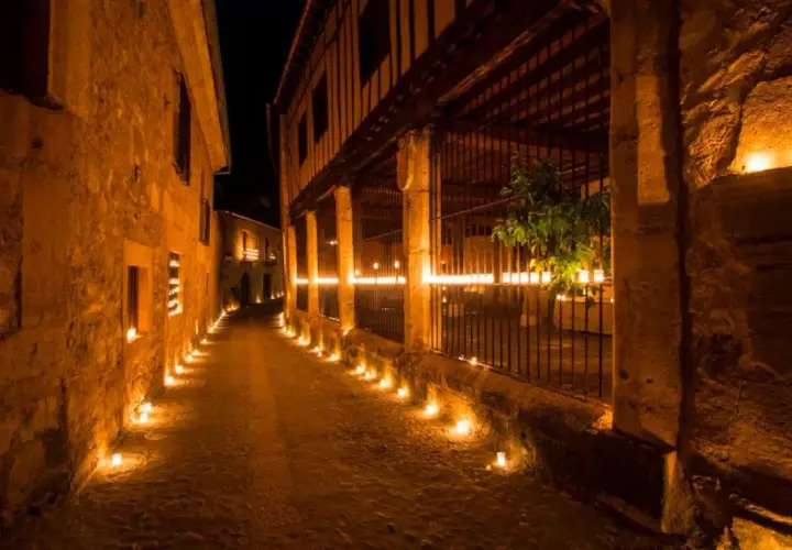 Calle empedrada iluminada por velas. Entradas gratuitas a Pedraza, un pueblo mágico.