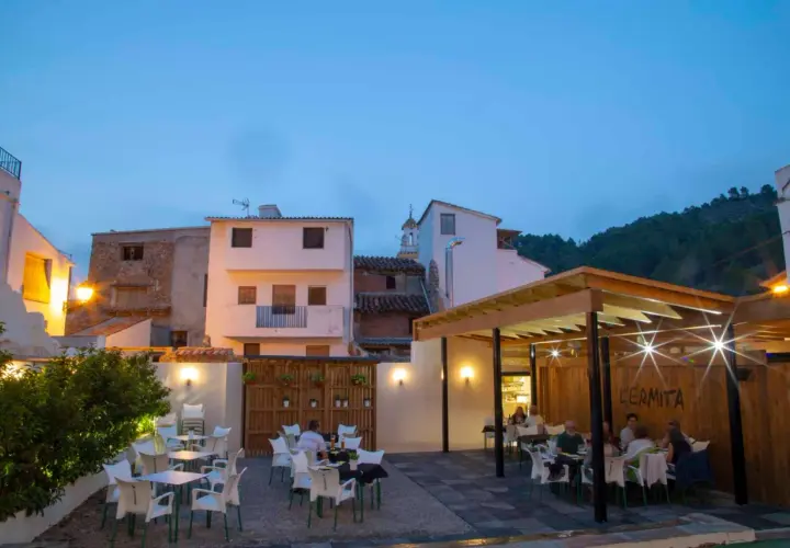 Terraza de restaurante en Montanejos, ideal para saber donde comer. Mesas y sillas dispuestas para disfrutar de la noche.
