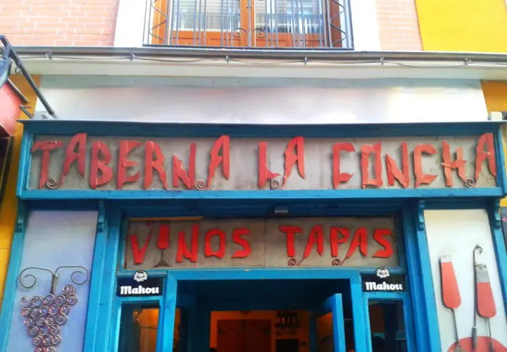 Fachada de la Taberna La Concha, con letrero rojo y azul. Ofrece vinos y tapas. ¡Las opiniones de la taberna La Concha son muy buenas!