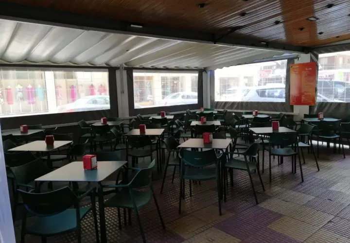 Terraza de bar con mesas y sillas verdes, ideal para saber donde comer en Cullera bien y barato.