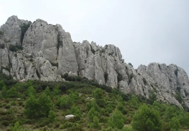 Impresionantes formaciones rocosas en la provincia mas montañosa de España, con vegetación verde en la ladera.
