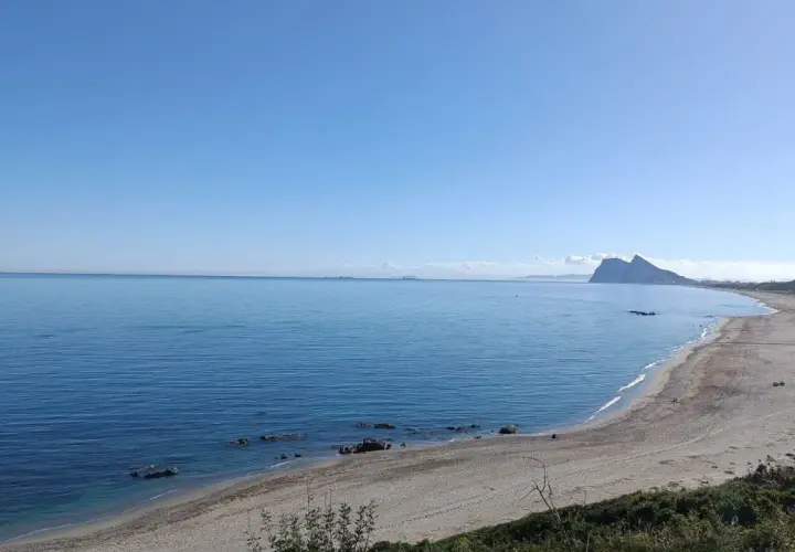 Vista de la playa la Alcaidesa con el Peñón de Gibraltar al fondo. Un día soleado y tranquilo, ideal para disfrutar del mar.