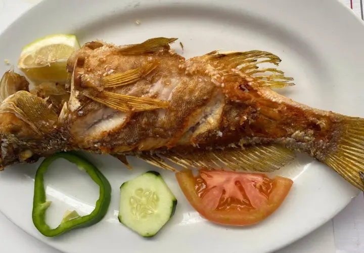 Pescado frito entero, servido con rodajas de limón, pimiento verde, pepino y tomate. ¡Una excelente opción de donde comer en El Hierro!