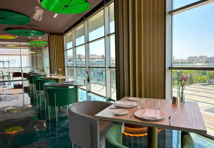 Mesas elegantemente puestas en un restaurante moderno con vistas panorámicas. Un lugar ideal para disfrutar de los mejores restaurantes Badajoz.