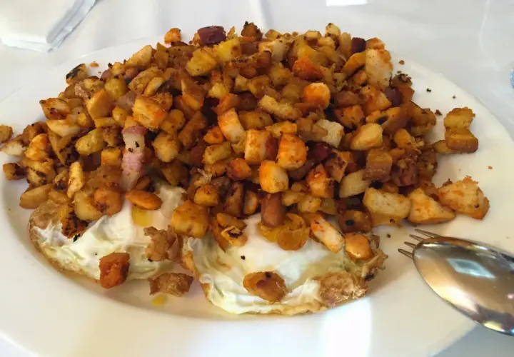 Plato de huevos fritos con patatas y pan tostado, ideal para leer las opiniones de bar restaurante Casa Goyo.