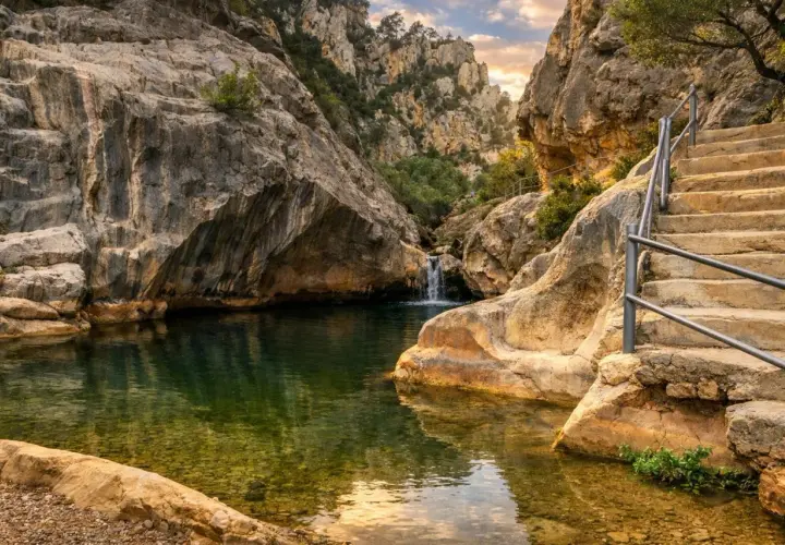 Un remanso de paz entre rocas, con una cascada y escaleras que invitan a explorar los **ríos en Tarragona**.