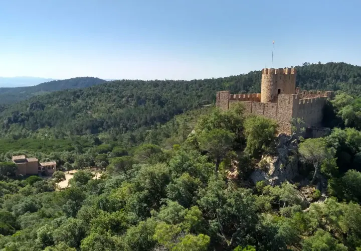 Castillo medieval rodeado de bosques frondosos, con un restaurante en su interior. El Castell de Brunyola ofrece vistas espectaculares.