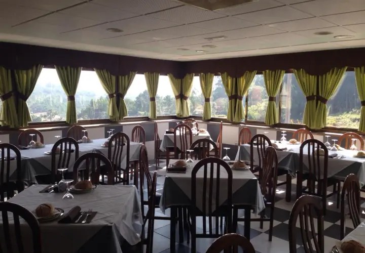 Mesas puestas en uno de los restaurantes en Cangas de Morrazo, con vistas al exterior.