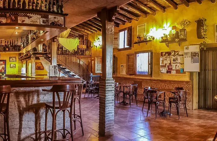 Ambiente acogedor en uno de los restaurantes en la huerta de Murcia. Barra de madera, taburetes altos y mesas rústicas invitan a disfrutar.