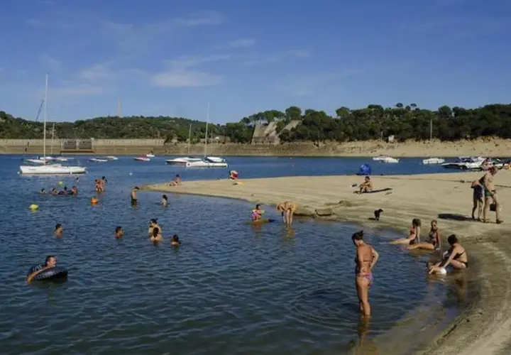Gente disfrutando de un día soleado en la playa, ¡quién diría que en Madrid hay playa! Barcos y bañistas en un día perfecto.