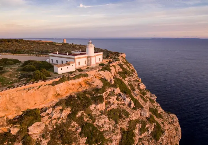 El mirador Sa Foradada, con su faro blanco y el mar azul al atardecer, ofrece vistas espectaculares.