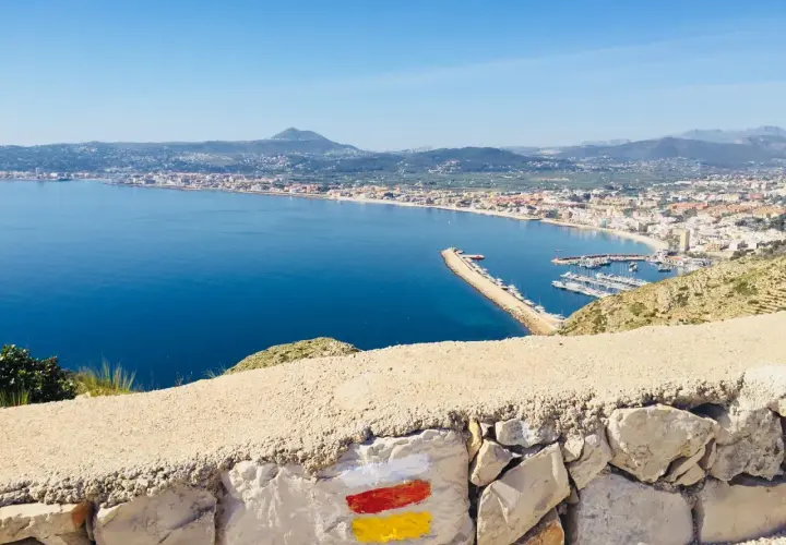 Vista panorámica de la bahía y el puerto deportivo, con el faro del Cabo de San Antonio al fondo.