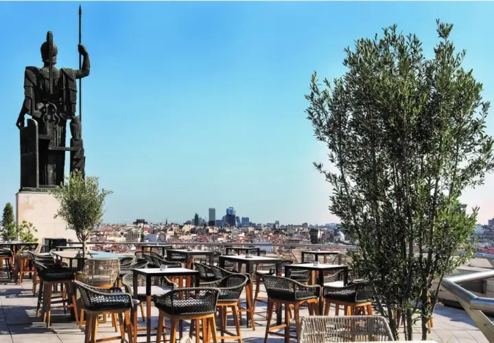 Terraza Bellas Artes Madrid con vistas a la ciudad, una estatua imponente y mesas listas para disfrutar.