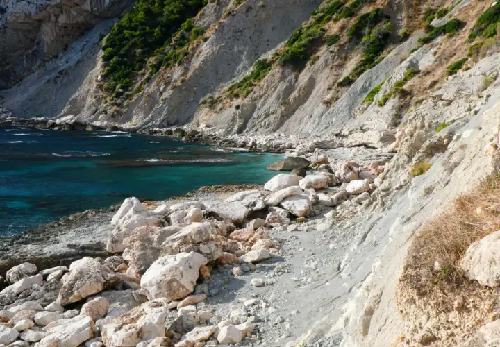 La cala del penyal, con sus aguas turquesas y rocas blancas, invita a la exploración.