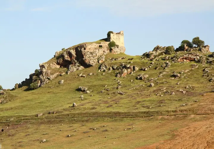 Ruinas de un castillo en una colina rocosa, un paisaje que evoca la historia de Navas de Tolosa, donde está.