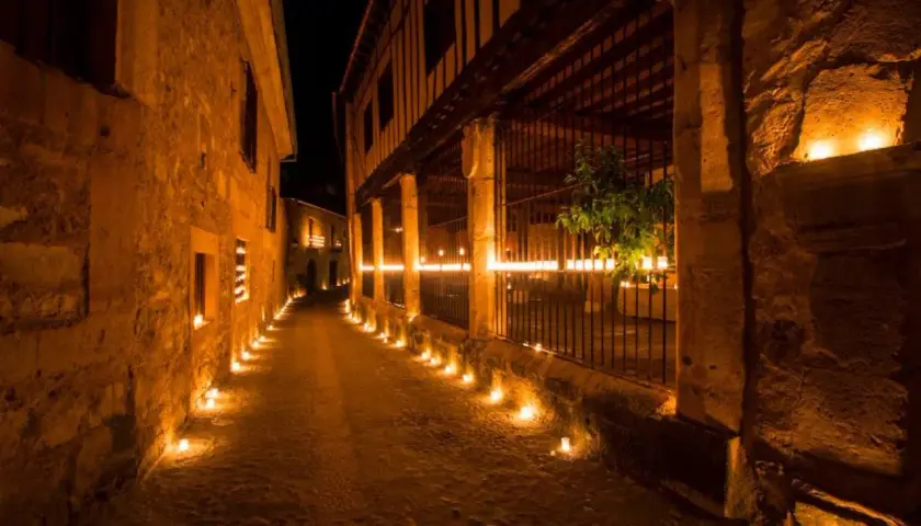 Calle empedrada iluminada por velas. Entradas gratuitas a Pedraza, un pueblo mágico.
