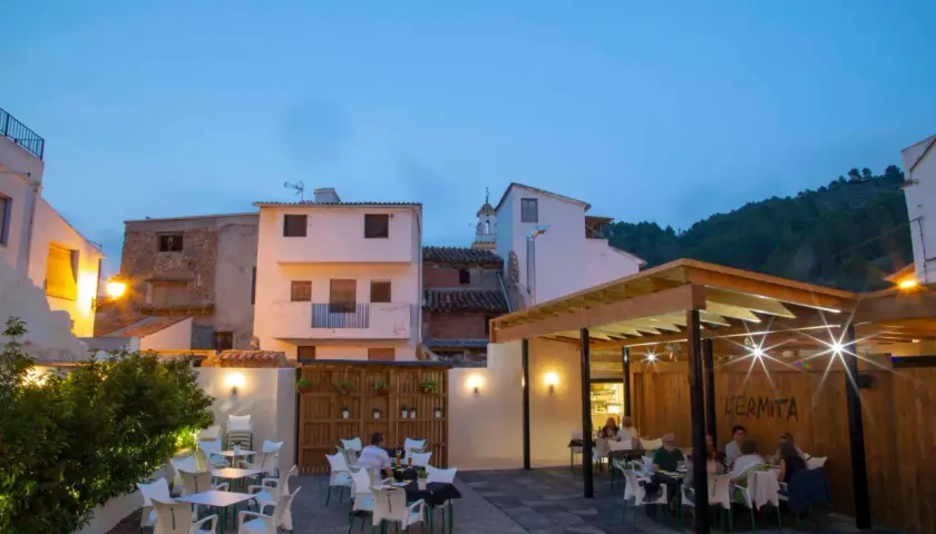 Terraza de restaurante en Montanejos, ideal para saber donde comer. Mesas y sillas dispuestas para disfrutar de la noche.