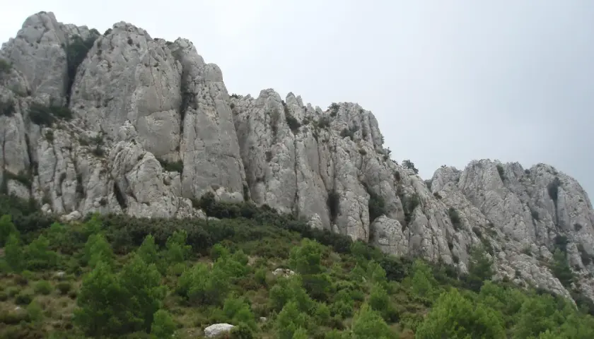 Impresionantes formaciones rocosas en la provincia mas montañosa de España, con vegetación verde en la ladera.