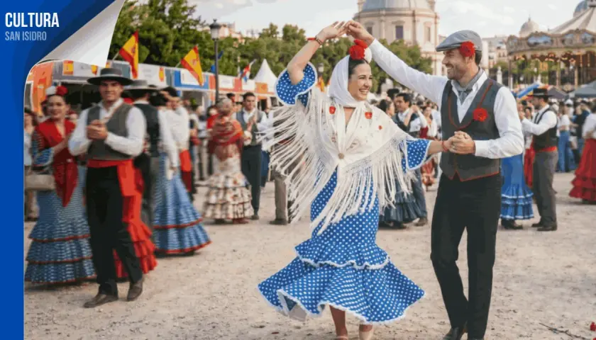 Pareja bailando flamenco en las fiestas de Alcobendas. Ella, con vestido de lunares y mantón de flecos; él, con chaleco y gorra.