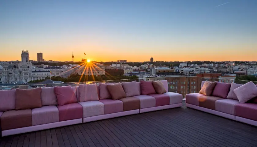 Sofás modulares rosas en una terraza con vistas a la ciudad al atardecer. Una casa suecia rooftop perfecta para disfrutar del sol.