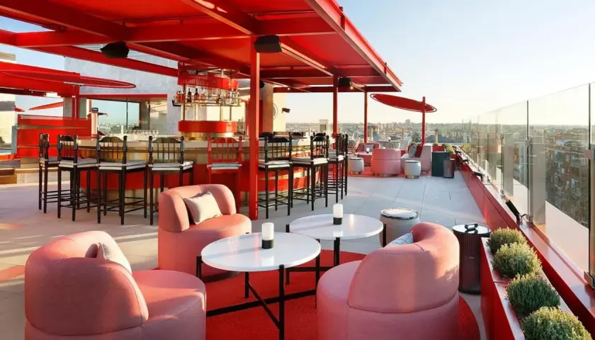 Modernas terrazas azoteas Madrid baratas con mobiliario rosa y barra roja, vistas a la ciudad.