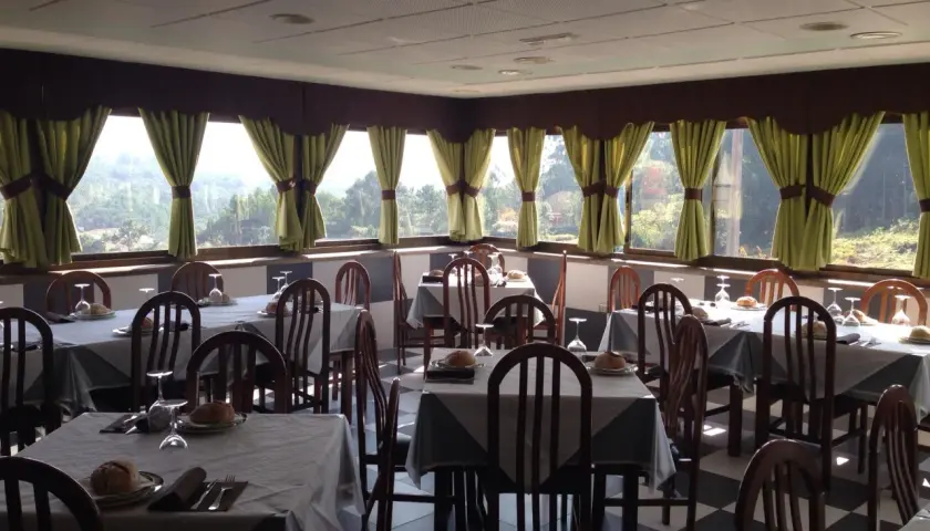 Mesas puestas en uno de los restaurantes en Cangas de Morrazo, con vistas al exterior.