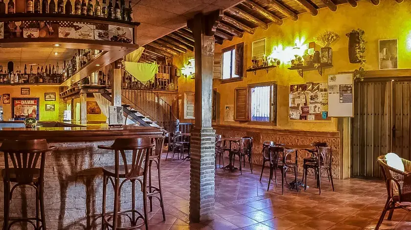 Ambiente acogedor en uno de los restaurantes en la huerta de Murcia. Barra de madera, taburetes altos y mesas rústicas invitan a disfrutar.