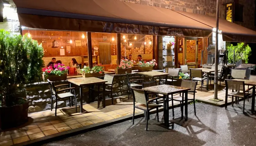 Restaurante "Horno de Lena" en Broto, con mesas al exterior y gente cenando. Ideal para saber donde comer en Broto.