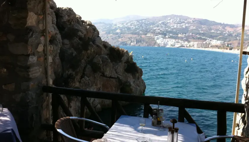 Mesa en restaurante el peñón con vistas al mar. Las reseñas destacan su ubicación privilegiada y la experiencia culinaria.