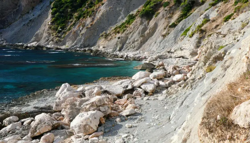La cala del penyal, con sus aguas turquesas y rocas blancas, invita a la exploración.