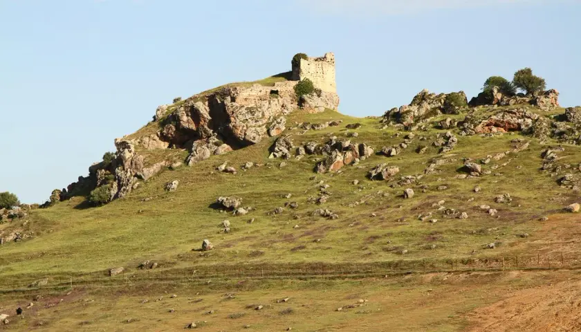 Ruinas de un castillo en una colina rocosa, un paisaje que evoca la historia de Navas de Tolosa, donde está.