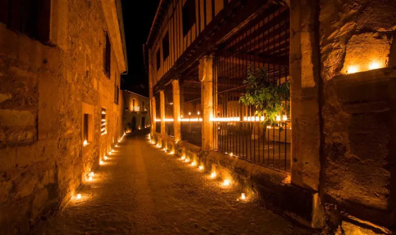 Calle empedrada iluminada por velas. Entradas gratuitas a Pedraza, un pueblo mágico.