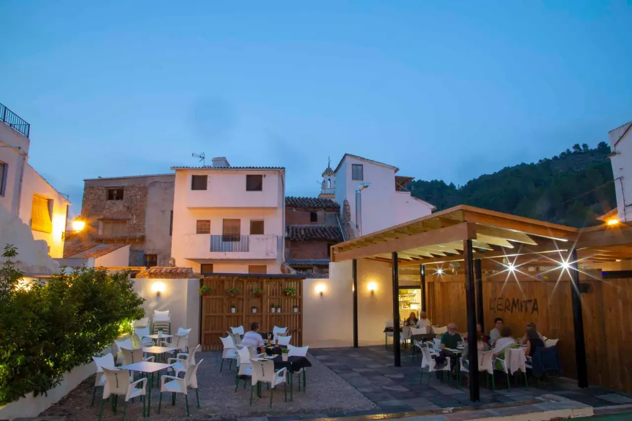 Terraza de restaurante en Montanejos, ideal para saber donde comer. Mesas y sillas dispuestas para disfrutar de la noche.