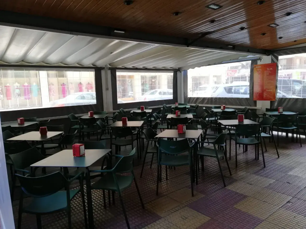 Terraza de bar con mesas y sillas verdes, ideal para saber donde comer en Cullera bien y barato.